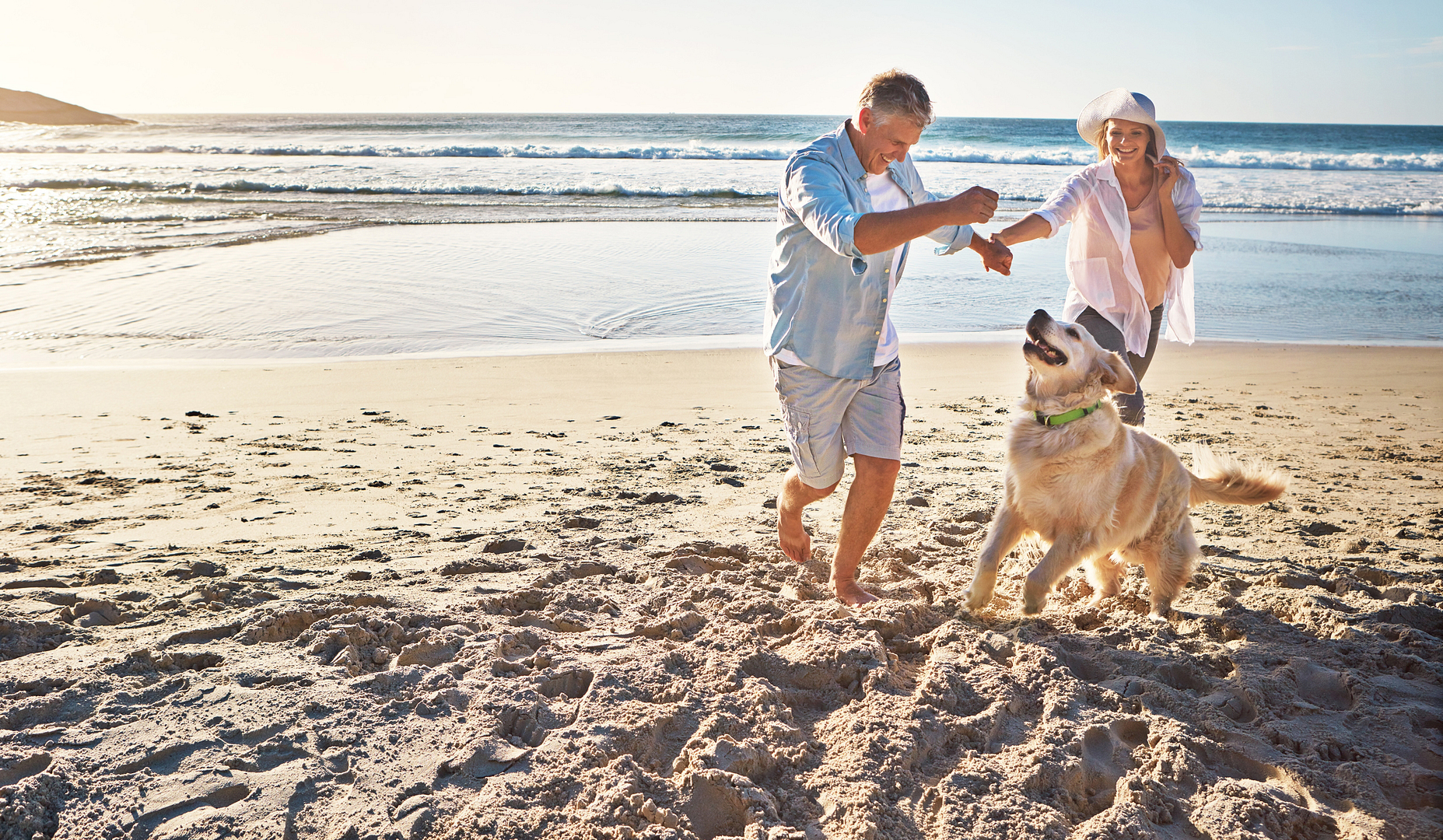 Couple walking on a Spanish beach-retire to Spain in 2025